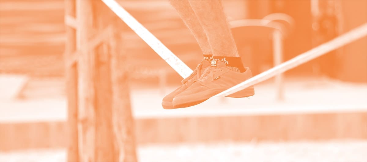 Man balancing on a tightrope, displaying only below his knees