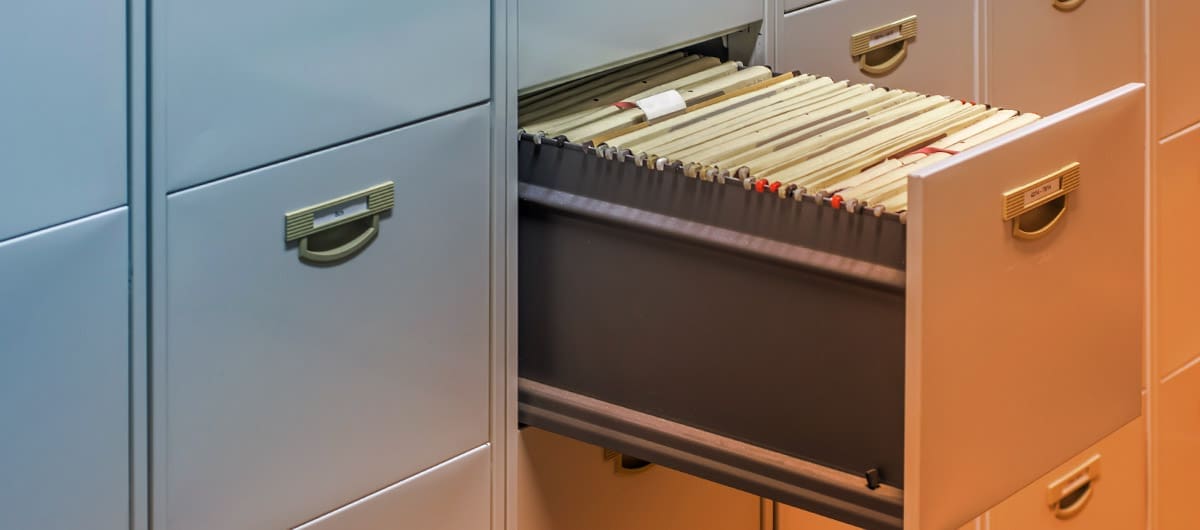 Up close view of an open filing cabinet filled with documents
