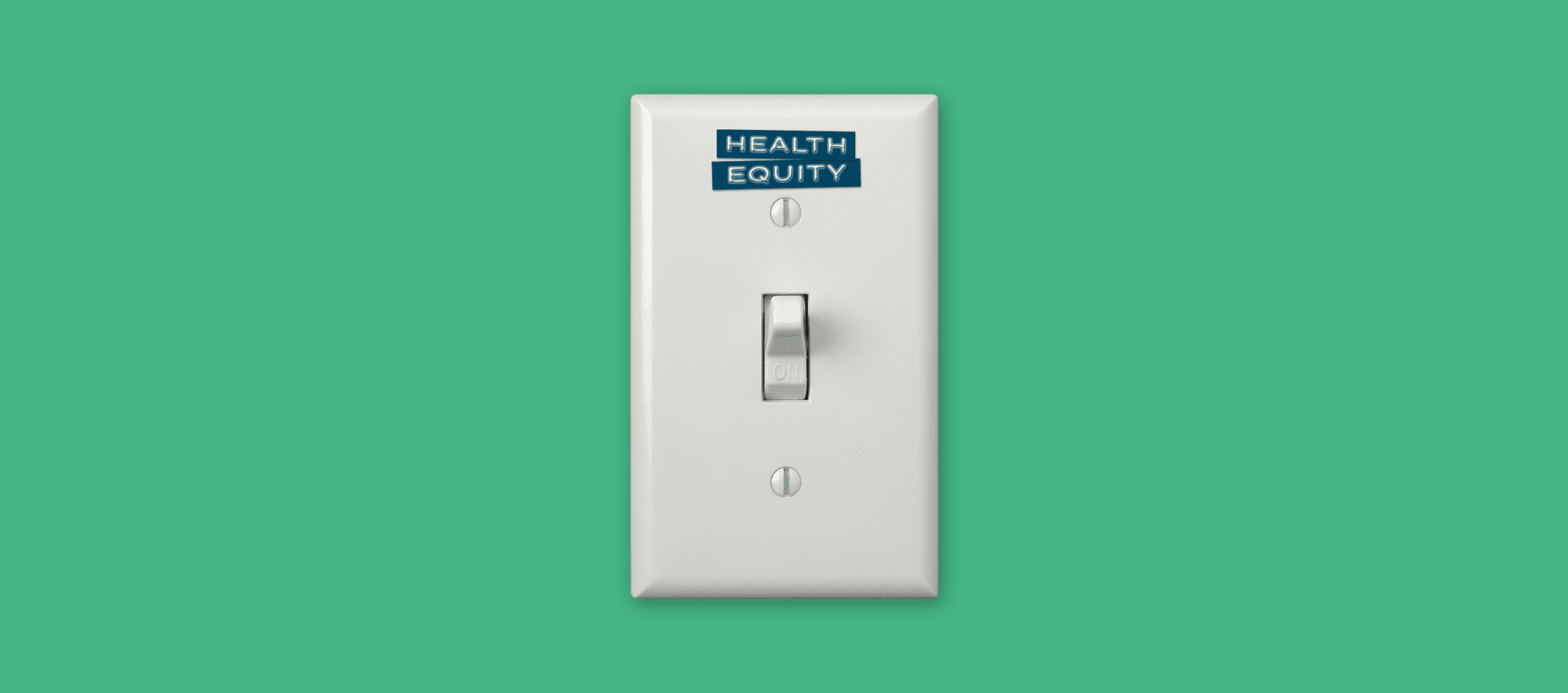 A turned on light switch with a sticker that reads "Health Equity" above the switch