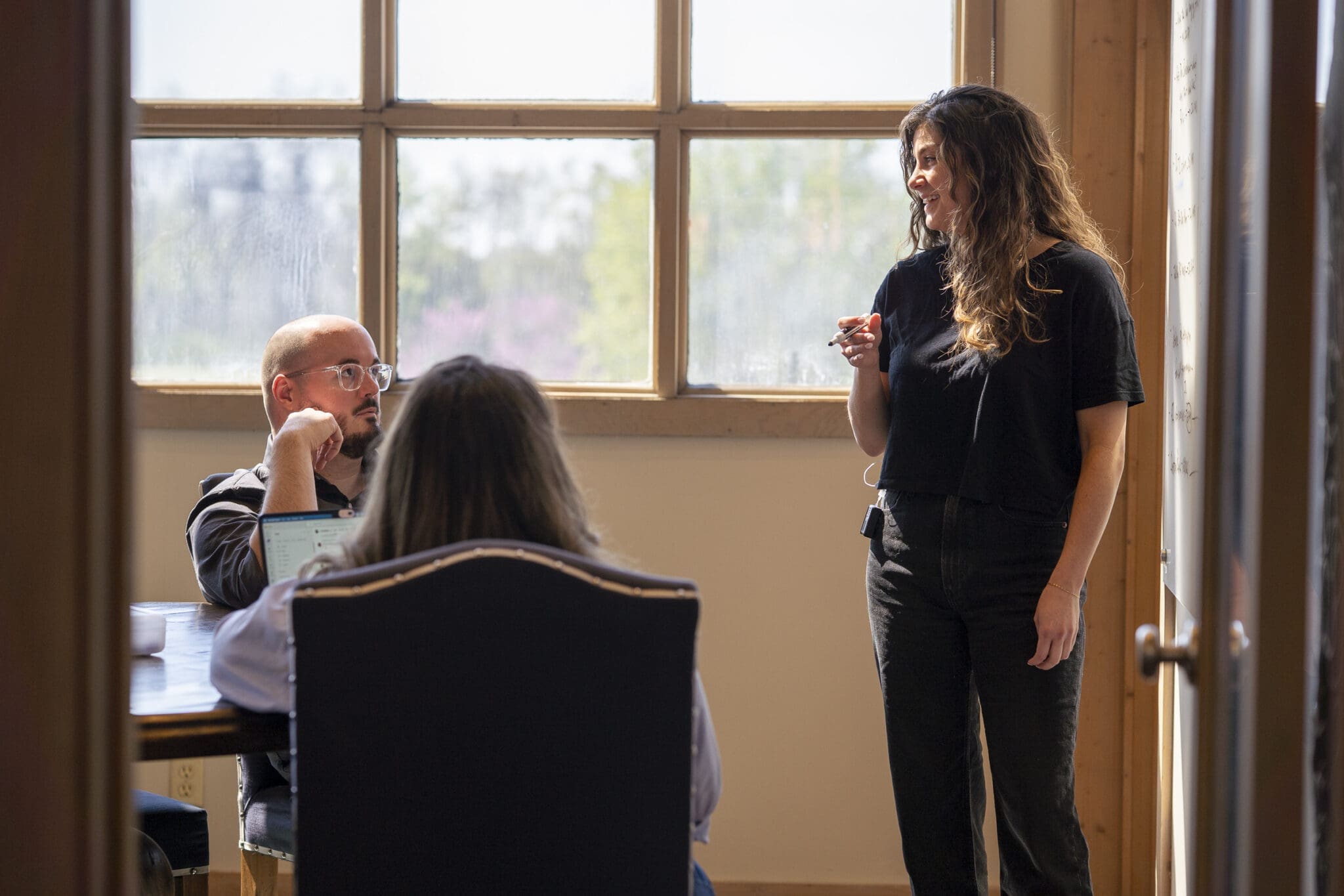 A creative leader stands at a whiteboard, iterating